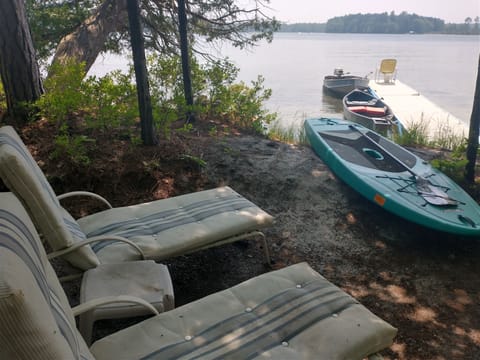 Loungers by dock, looking at SUP Board, canoe, 14' boat with motor