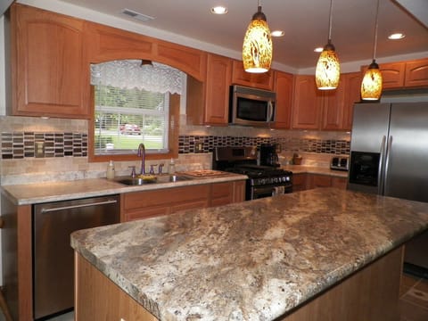 Open kitchen with island & custom tile design.