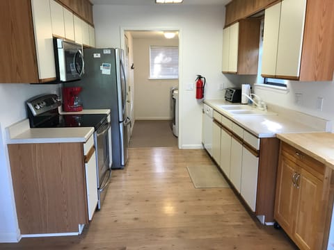 Open galley kitchen, new appliances, stocked with all entertaining/cooking needs