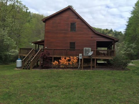 Side view of cabin with large grassy area 