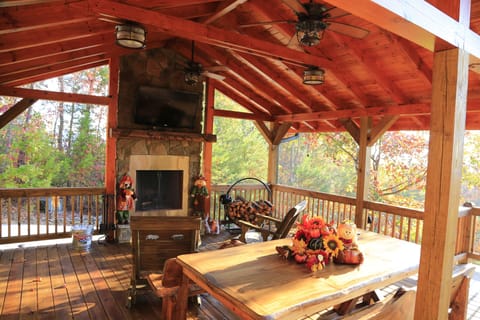 Covered deck with large tv, ceiling fans, rockers, and a view for family fun