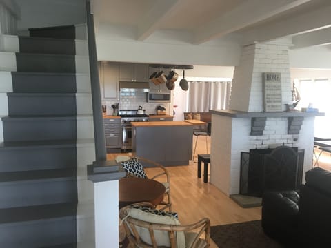 Stairs to second floor (left), kitchen, fireplace, dining room(behind fireplace)
