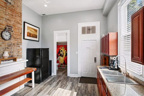 Full kitchen - doors to backyard and full bathroom; original 100+ year old brickwork