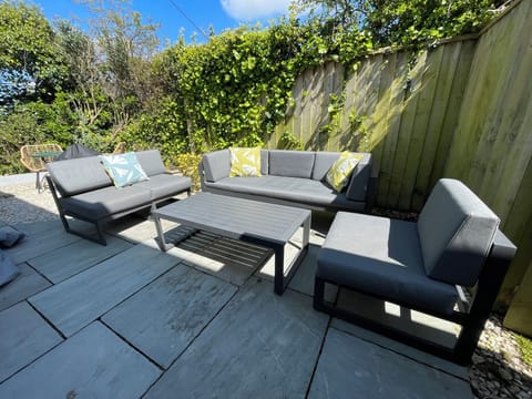 Comfortable seating on garden terrace.  And a warm shower for sandy dogs !