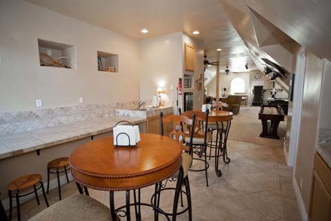The game room kitchen area has a dorm size frig, microwave and 2 pub tables