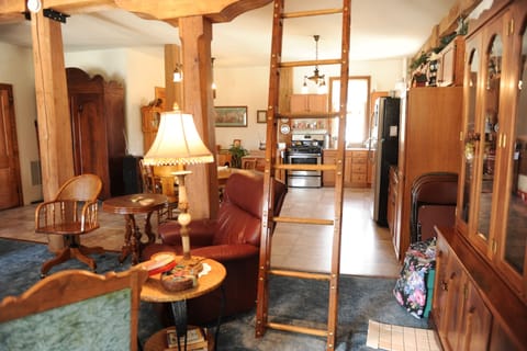 View from queen bed #2 through living area to kitchen. Antique fireman's ladder.
