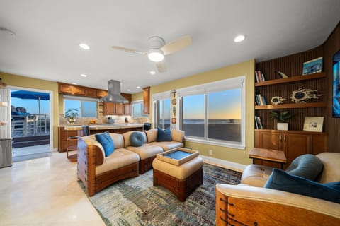 Beachfront living, kitchen, patio beyond. Whitewater, strand & sunset views.