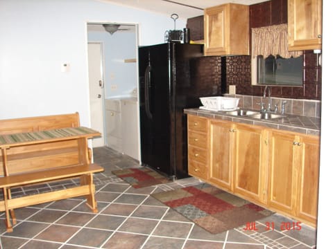 Utility room off of kitchen.  Side by side refrigerator and table with benches.