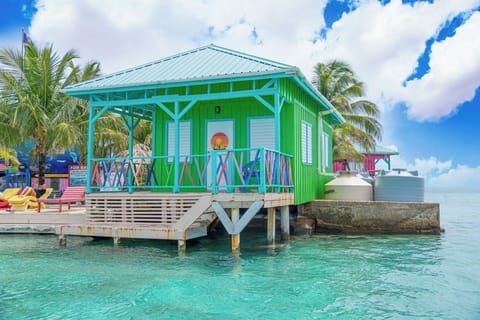 Colorful overwater cabana surrounded by crystal-clear Caribbean waters.