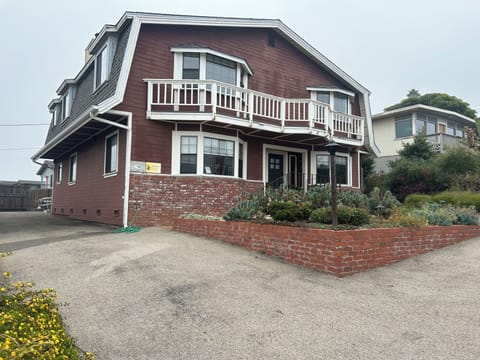 Front exterior of Ocean's Breeze.  Four large bay windows facing west to the sea