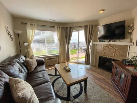 Charming living area with fireplace, leather seating, and serene patio views for ultimate relaxation.
