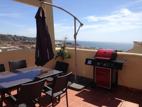 Terrace with access from lounge with gas barbecue, dining table and parasol.