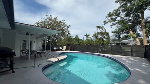 Screened pool with lounge chairs and covered patio area
