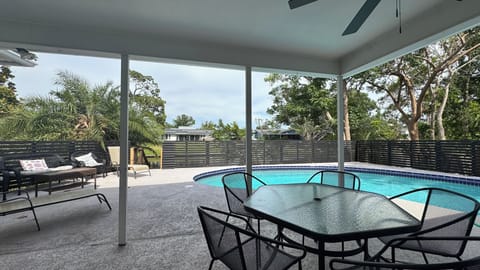 Pool with adjacent covered outdoor dining patio and seating