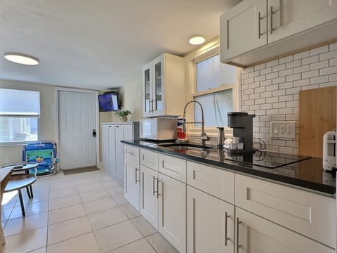 A modern kitchen with long counter space, cabinets, and appliances open to the living area.