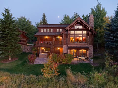 Your mountain lodge retreat awaits as twilight settles in, with warm light spilling from every window and the moon rising over towering pines. Feel the magic of autumn evenings on your private deck.