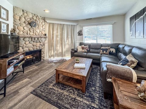 Warm up by the stone fireplace in this rustic-chic living room with comfy seating.