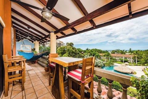Private balcony overlooking the resort-style pool and shimmering ocean horizon — the perfect spot to relax, sip coffee, or watch the sunset. Stay steps from the beach in this centrally located Tamarindo condo with tropical views and coastal charm.