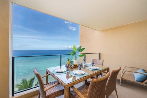 Enjoy a serene outdoor dining space overlooking turquoise waters and swaying palms