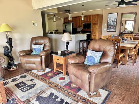 Living room with 65 in TV, two recliners, sleeper sofa and access to the patio.