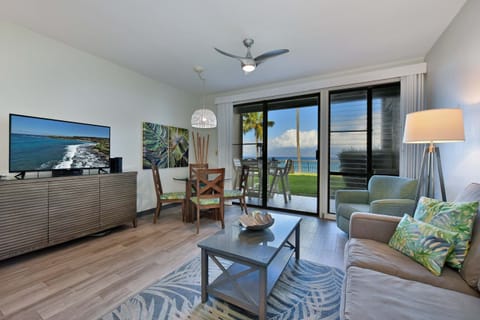 Unwind in this bright, open living space featuring plush seating, a flat-screen TV, a cozy dining nook, and floor-to-ceiling glass doors opening to spectacular ocean views.