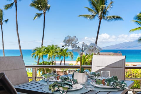Oceanfront lanai view with palm trees and sweeping vistas of the Pacific.