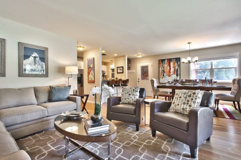 Cozy living room with sectional couch, club chairs, gas fireplace, and HDTV. 