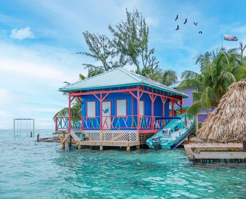 Colorful overwater cabana surrounded by crystal-clear Caribbean waters.