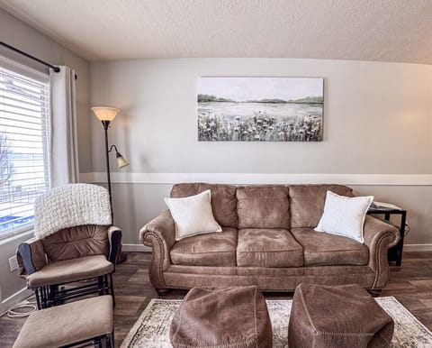 Cozy seating with soft lighting and serene art—perfect for relaxing or reading by the window.
