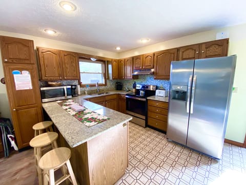 Large refrigerator in main kitchen w ice maker, spare fridge in kitchenette.