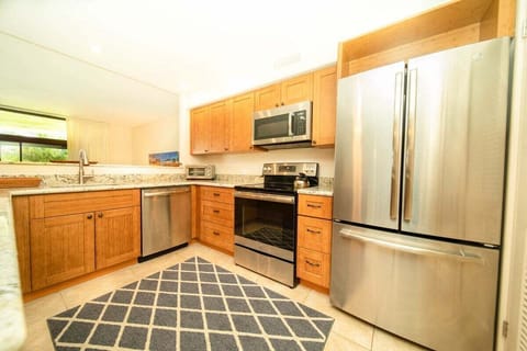 Enjoy a bright kitchen with stainless steel appliances and warm wood cabinetry