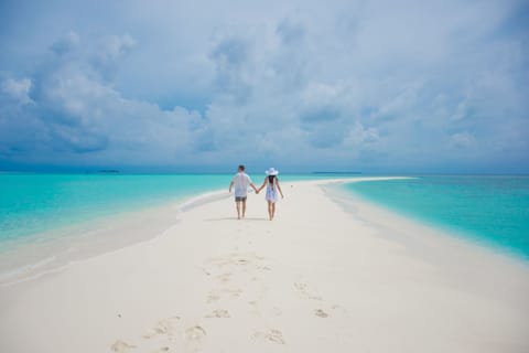 On the beach, white sand, sun loungers, beach umbrellas