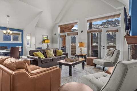 Large living room area with 16 foot vaulted ceiling. There is a queen-sized sofa ben in the living room.