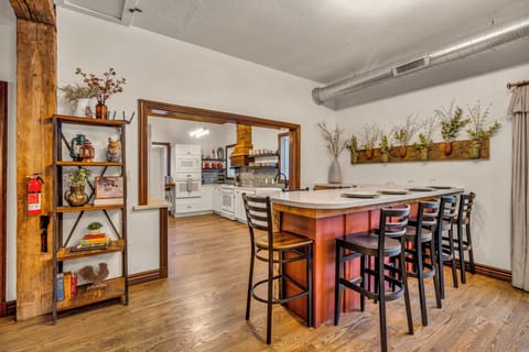 A warm, inviting kitchen and bar area designed for gathering. Perfect for sharing meals, morning coffee, or late-night conversations, with ample seating and a cozy rustic vibe that brings family and friends together in comfort.