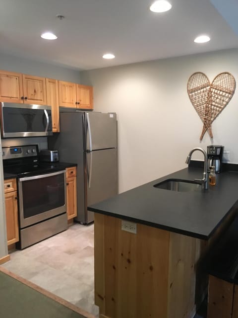 Kitchen with stainless steel appliances & leathered granite countertops.