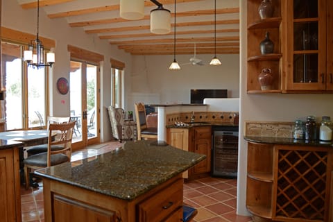 Gourmet kitchen island looking to breakfast nook to the left, wet bar straight ahead overlooking living room fireplace & large flat screen satellite TV