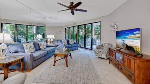 The living room has plenty of seating & triple sliding glass doors to balcony...