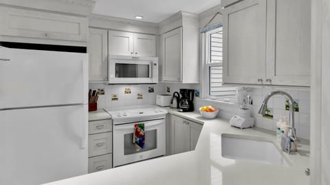 Your fully equipped kitchen awaits with crisp white cabinetry, granite counters, and stainless appliances—perfect for cooking memorable meals together.