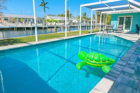 Sunlit poolside retreat with serene waterfront views