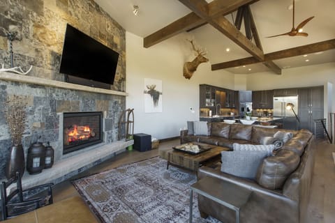 The living room with views of the ski resort. Large, vaulted ceilings, floor to ceiling windows, and fireplace