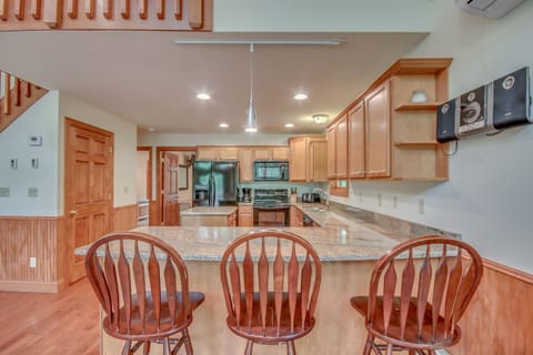 Kitchen with Counter, High Chairs, Refrigerator, and Microwave.