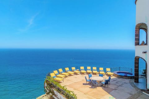 Imagine lounging on your private sun terrace with endless blue ocean views. This Mediterranean-style patio offers comfortable seating, a dining table for al fresco meals, and the soothing sound of waves below.