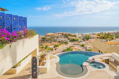 A stunning coastal oasis awaits you—this private pool and hot tub sit framed by lush bougainvillea and sweeping ocean views, offering the perfect setting for your sun-soaked escape.