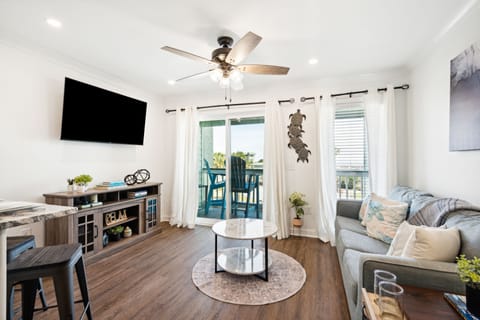 Living room area, kitchen, and balcony.