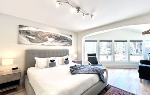 The spacious primary bedroom has a brand new king bed, large flat screen TV and a black leather sofa in the corner.