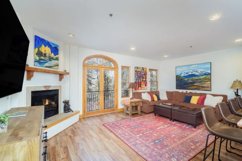 Settle into your cozy living room where mountain art adorns walls, a fireplace warms winter evenings, and French doors open to scenic views.