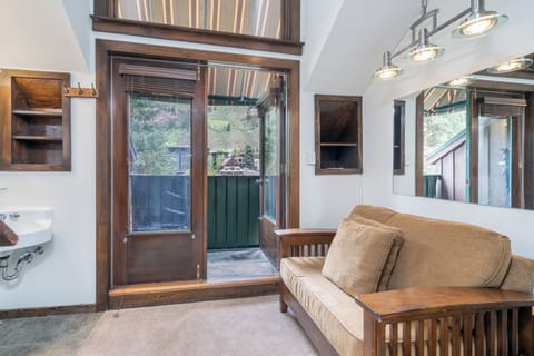 Unwind in your bright mountain retreat. Rich wood accents, vaulted ceilings, and a comfy sofa invite you to relax after a day of adventure. Step outside to your private space overlooking the slopes.