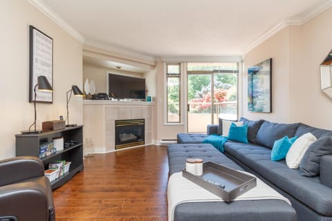 Welcome to your cozy living room sanctuary! Relax in a bright, open space featuring a fireplace and large windows.