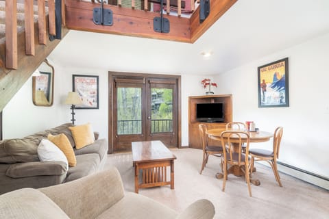 Relax in your inviting living space with cozy seating, warm wood accents, and doors opening to a private balcony. Unwind after a day exploring the nearby mountains.