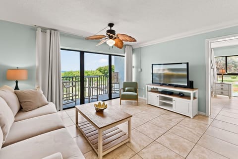 Bright and airy living room with a ceiling fan and stunning balcony views
